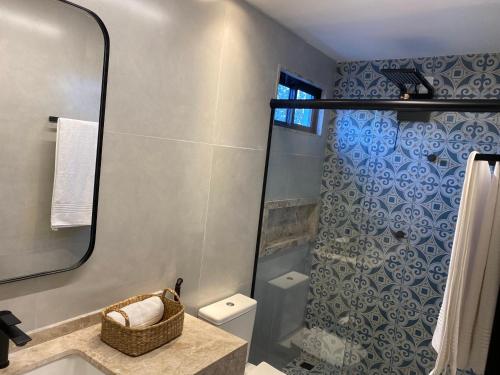 bagno con doccia, lavandino e specchio di POUSADA CAFÉ DU'LIRIO a Lagoa Nova