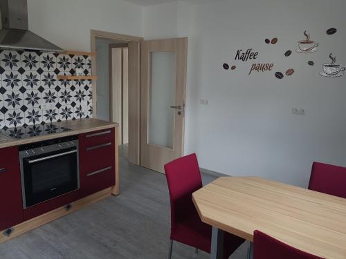 a kitchen with a wooden table and a table and a table and chairs at Ganze Monteurswohnung mit 2 Schlafzimmern 90 qm in Bad Salzschlirf
