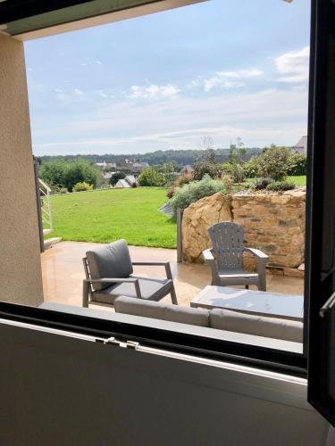 a view of a patio with two chairs and a couch at Les chambres du Roc'h Hir à Loguivy de la Mer in Ploubazlanec