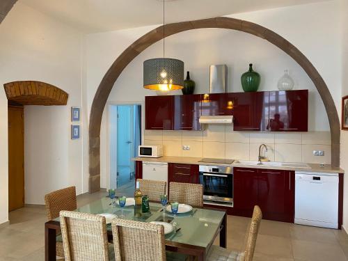 cocina con mesa y sillas y cocina con arco en Les Arches du Couvent - classé 5 étoiles, en Marmoutier