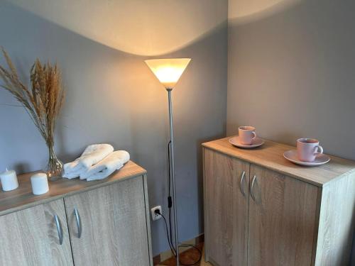 une chambre avec une lampe et deux commodes avec des tasses et des serviettes dans l'établissement Lawendowa Przystań - Apartament, 