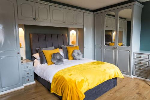 a bedroom with a large bed with a yellow blanket at Comfort at Keldy in Tettenhall