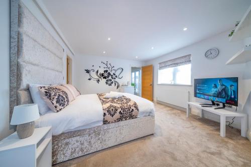 a bedroom with a large bed and a television at *RC7C* For your most relaxed & Cosy stay + Free Parking + Free Fast WiFi * in Batley