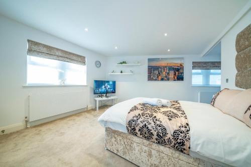 a bedroom with a large bed and two windows at *RC7C* For your most relaxed & Cosy stay + Free Parking + Free Fast WiFi * in Batley