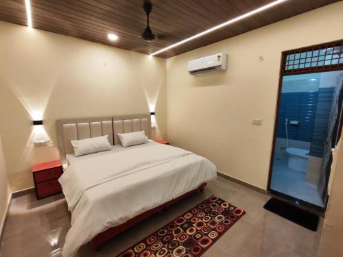 1 dormitorio con cama blanca, ventana y alfombra roja en Sunrise Homestay, en Agra