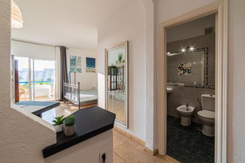 a bathroom with a toilet and a view of a balcony at Sunset Escape in Playa Paraiso