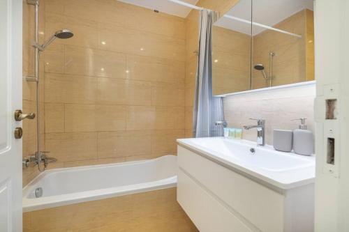 a bathroom with a tub and a sink and a mirror at Serene Studio & Sea View & Brand New Listing in Ras al Khaimah