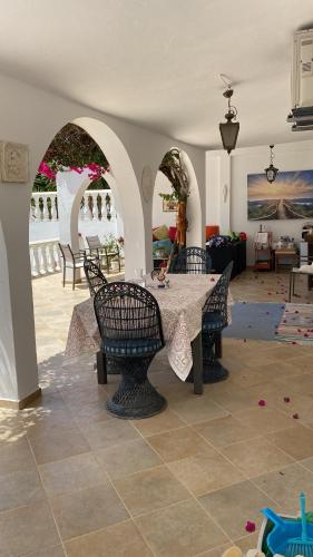 a dining room with a table and chairs at Casa Paraiso studio salon coin repas kitchenette extérieure grande terrasse privée jardin et piscine près des plages de FUSETA et de la RIA FORMOSA in Moncarapacho
