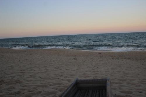 a wooden box sitting on a beach near the ocean at Ecolux in Marracuene