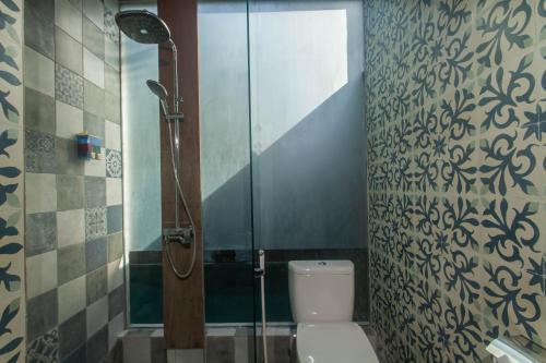 a bathroom with a shower stall and a toilet at Sari Dana Villas in Sanur