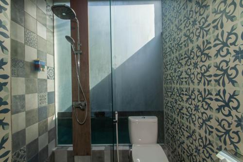 La salle de bains est pourvue d'une cabine de douche et de toilettes. dans l'établissement Sari Dana Villas, à anur