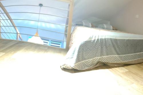 Bett mit Kissen in einem Zimmer mit Fenster in der Unterkunft Le cocon in Lèves