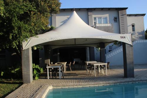 a white tent with tables and chairs next to a pool at Ecolux in Marracuene