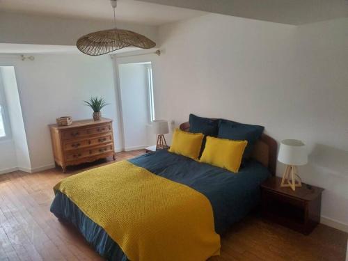 - une chambre avec un lit doté d'une couverture jaune et bleue dans l'établissement La Maison Du Puy, à Le Puy-Saint-Bonnet