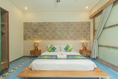 a bedroom with a king sized bed and two tables at Sari Dana Villas in Sanur