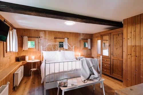 a bedroom with a white bed and wooden walls at SCHILCHERLANDLEBEN - Kirchberg in Sankt Stefan ob Stainz