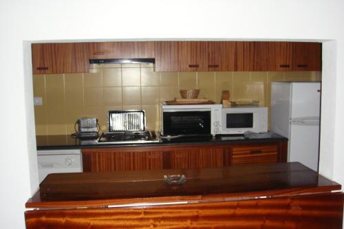 a kitchen with a stove and a microwave and a refrigerator at Apartamento Duplex de 3 Quartos com vista in Lavre