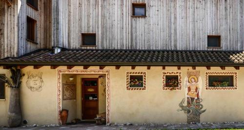 a small house with a door and windows at BioAgriturismo Vegan Campo di Cielo in Cesiomaggiore