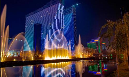 a large building with a fountain in front of a city at Orbi hotel sea view in Kuwait