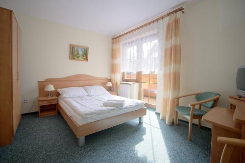 a bedroom with a bed and a tv and a window at Willa Park in Zakopane