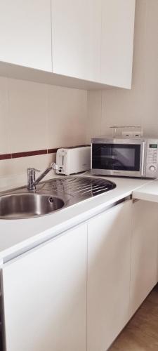 a kitchen with a sink and a microwave at Estudio en Villalonga in Pontevedra