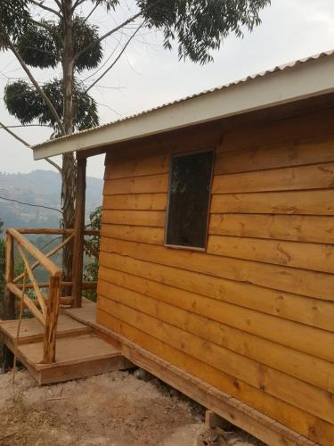 a log cabin with a porch and a window at Eagle Peak homestay in Kabale