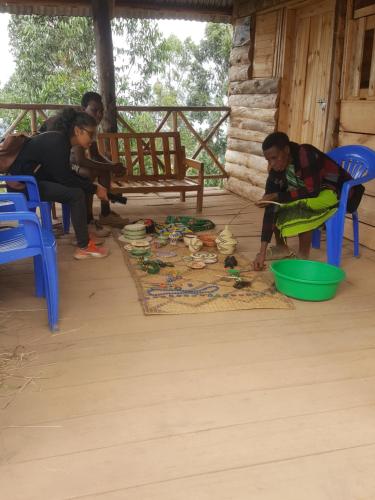 een groep vrouwen die op een veranda spelen bij Eagle Peak homestay in Kabale