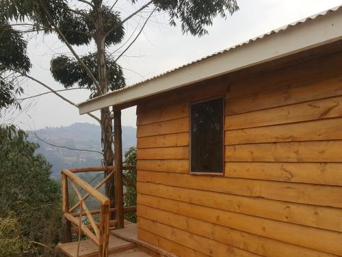 Cabaña de madera con porche y ventana en Eagle Peak homestay en Kabale