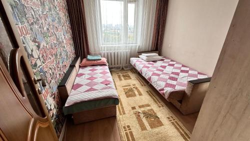 2 letti posti in una stanza con finestra di 4-х комнатная квартира в центра города Астана a Astana