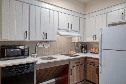 a kitchen with white cabinets and a white refrigerator at Staybridge Suites Allentown Airport Lehigh Valley by IHG in Allentown