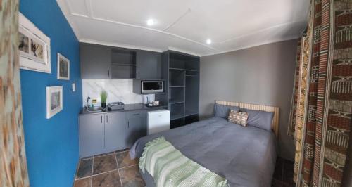 a small bedroom with a bed and a kitchen at Matusadona Guest Lodge in Hillcrest