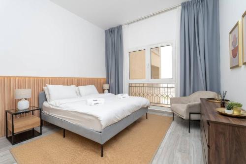1 dormitorio con 1 cama, 1 silla y 1 ventana en Luxurious Golf View & 1BD & Brand New Listing en Ras al-Jaima