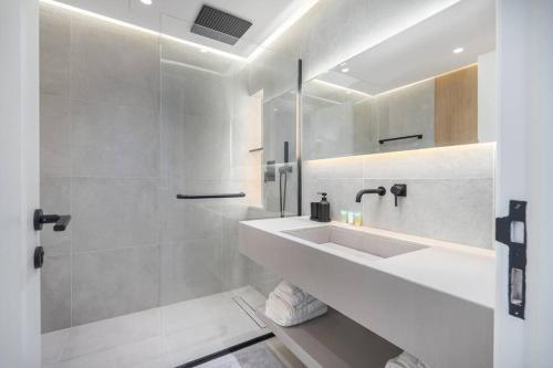 uma casa de banho branca com um lavatório e um chuveiro em Luxurious Golf View & 1BD & Brand New Listing em Ras al-Khaimah