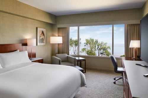 a hotel room with a bed and a large window at The Westin San Francisco Airport in Millbrae