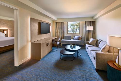 a hotel room with a couch and a bed and a television at The Westin San Francisco Airport in Millbrae