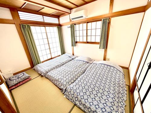 een slaapkamer met 2 bedden in een kamer met ramen bij 浜町小院别馆 in Takamatsu