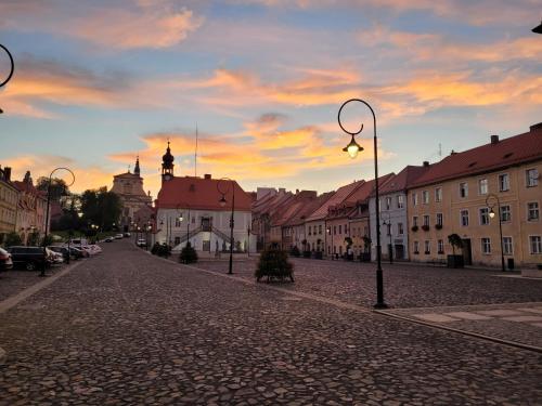 a city street with buildings and a sunset in the background at Rynek 31 in Lubomierz