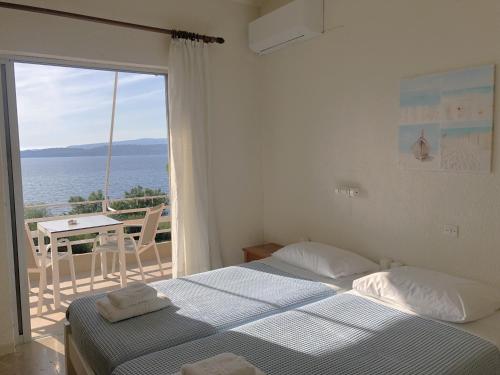 una camera con due letti e vista sull'oceano di Galini Studios and Apartments a Lassi