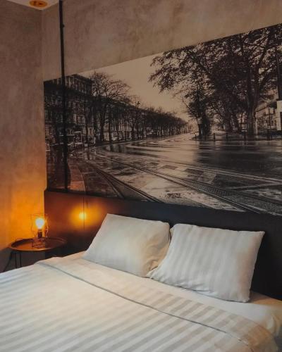 ein Bett mit einem schwarz-weißen Bild an der Wand in der Unterkunft nava one in Candi