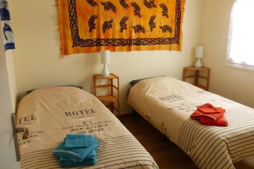 une chambre avec deux lits avec des serviettes dessus dans l'établissement Villa Evasion à Sète, à Sète