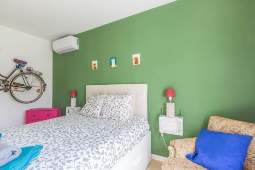 ポルシェスにあるCrastos pool & beach houseの緑の壁のベッドルーム1室(白いベッド1台付)