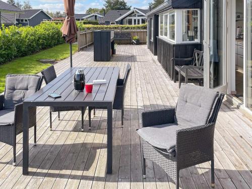patio ze stołem, krzesłami i parasolem w obiekcie 6 person holiday home in Hadsund w mieście Haslevgårde