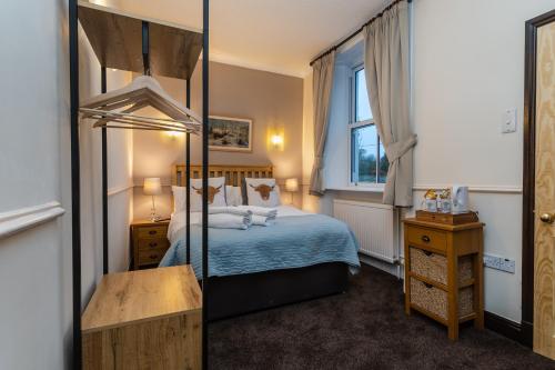 a bedroom with a bed and a mirror at The Wheatsheaf Inn in Carperby