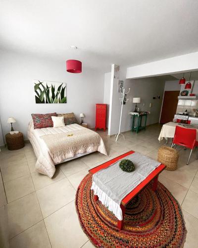 a bedroom with a bed and a table in it at Maison Rouge Puerto Madryn in Puerto Madryn