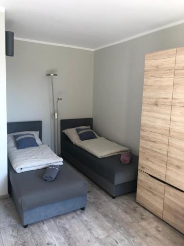 two twin beds in a room with a dresser at Przytulne mieszkanie przy parku Modrzewie in Elblag