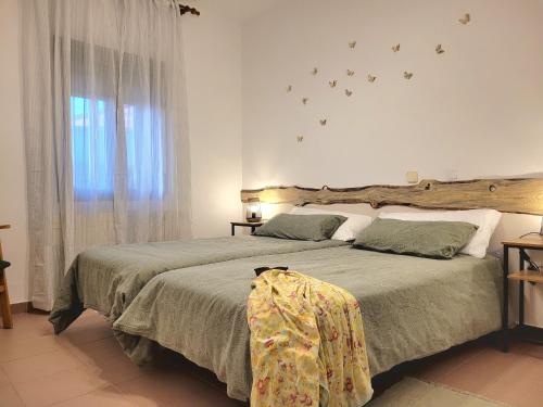 a bedroom with two beds and a window with birds on the wall at HOSTEL Villanueva in Villanueva de Alcorón