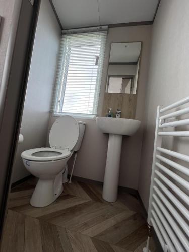 a bathroom with a toilet and a sink at Lake View 92 in Millom