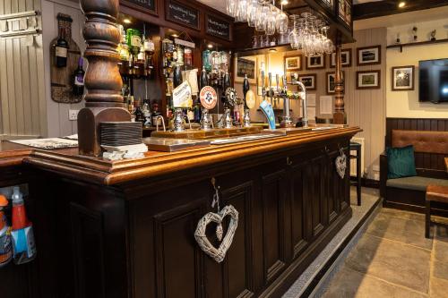 un bar con bancone in legno in un pub di The Wheatsheaf Inn a Carperby