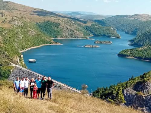 a group of people standing on a hill overlooking a lake at Apartman Teodora Uvac in Nova Varoš