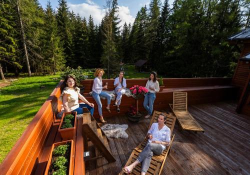 un groupe de personnes assises sur une terrasse dans l'établissement Villa Drosera s wellnessom, Račkova dolina v Západných Tatrách, à Pribylina